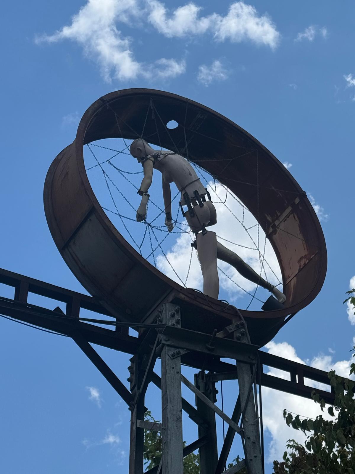 Detail der Figur im Stahlrad vor blauem Himmel